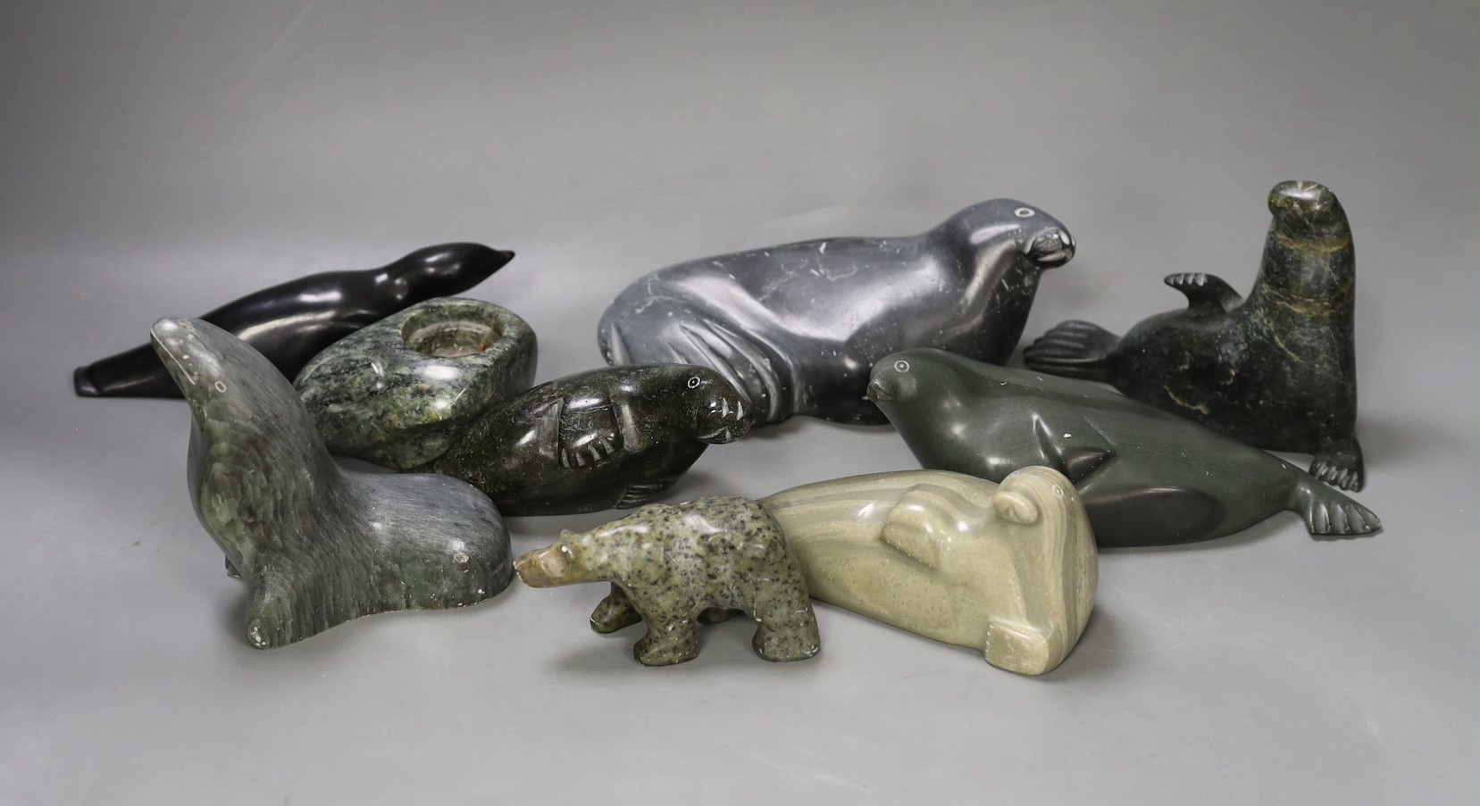 A collection of carved Canadian Inuit seal figures, largest 18 cm long (9)